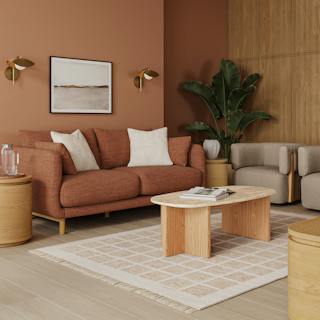 Modern living room with a light gray sofa, pink pillows, and wooden furniture.