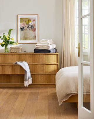 Kouva dresser in natural oak with vertical wood detailing, set in a bright, modern room.