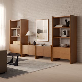 Torme 34" Tall Bookcase with Storage and 72" Media Unit in Smoked Oak finish, styled with art and books in a warm living room