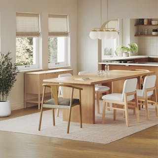 A modern dining room with a wooden table, mixed chairs, and bold lighting.