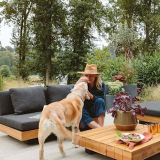 Lubek 50" Outdoor Low Loveseat in Slate Gray, featuring a person playing with a dog. Photo by @em_henderson