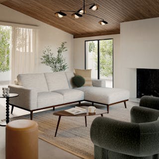 Ivory fabric sofa with walnut legs in a bright modern living room.