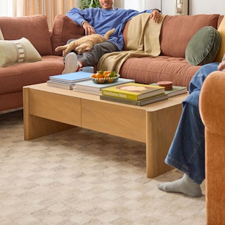 Torme 48" Storage Coffee Table in White Oak, styled in a bright and colourful room with people lounging on a sofa