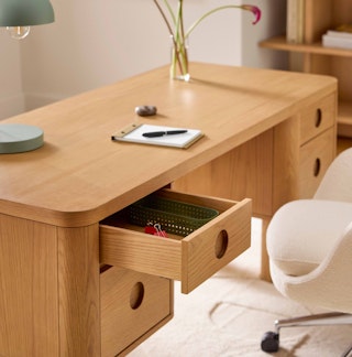 Detailed view of uppermost storage drawer and rounded handle details on the Adel 66.5" Desk in White Oak