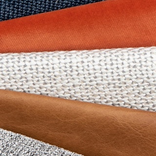 A stack of various fabric and leather swatches