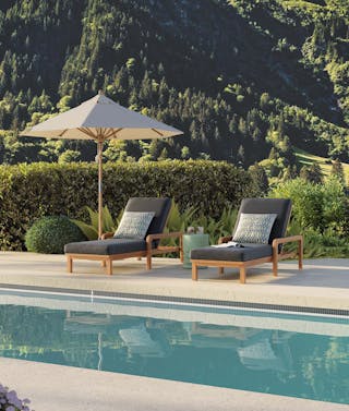 Poolside patio featuring two chaise lounges, umbrella, and side table. Curated by Article's interior design team