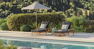Poolside patio featuring two chaise lounges, umbrella, and side table. Curated by Article's interior design team