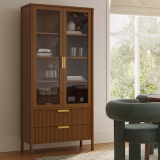 Dining room treasures on display within the glass doors of the Liv 35.25" Glass Cabinet in Walnut
